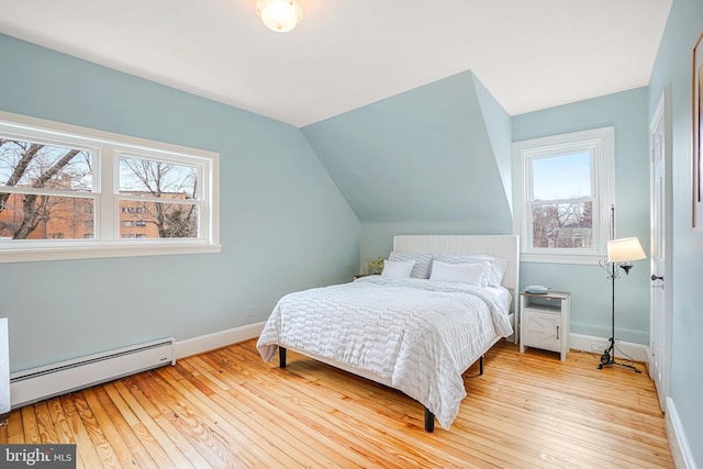 bedroom with baseboard heating, lofted ceiling, light hardwood / wood-style floors, and multiple windows