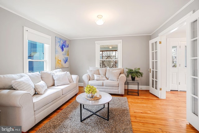 living room with wood-type flooring, ornamental molding, and french doors