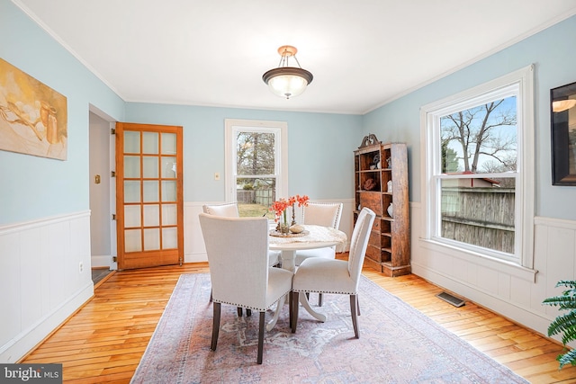 dining area featuring ornamental molding and light wood-type flooring