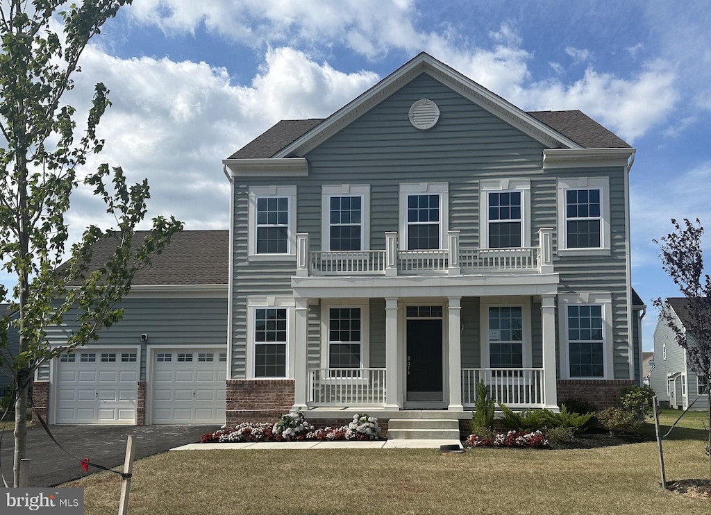 view of front of property with a porch, a garage, and a front lawn