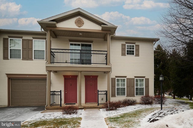 view of property with a balcony and a garage