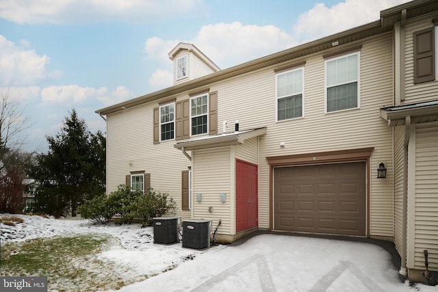 view of front property featuring a garage and central AC unit