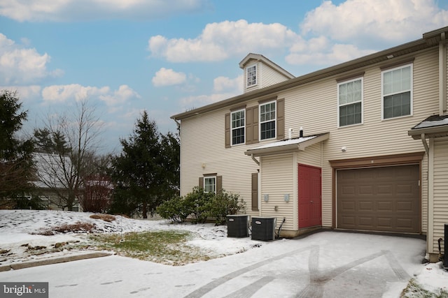 view of front of home with a garage and central air condition unit