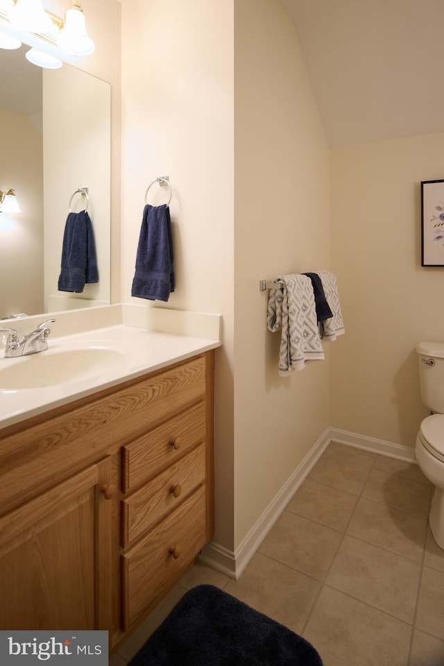 bathroom with lofted ceiling, vanity, toilet, and tile patterned flooring