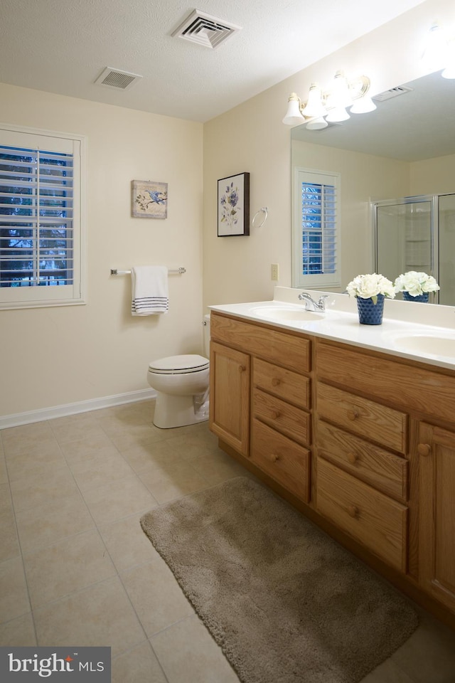 bathroom featuring vanity, an enclosed shower, toilet, tile patterned floors, and a textured ceiling