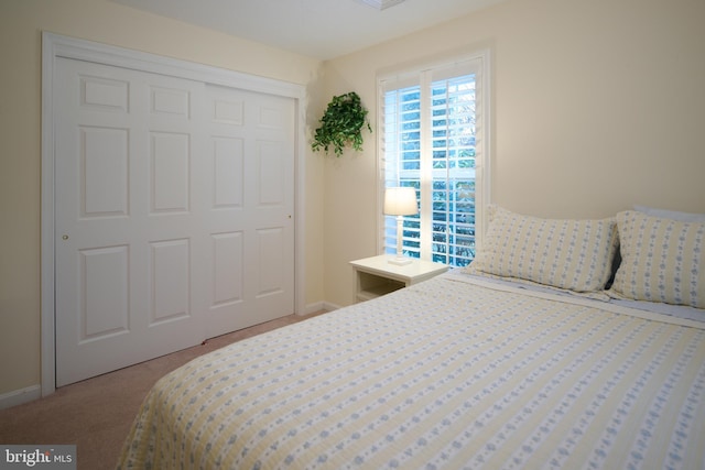 bedroom featuring light colored carpet and a closet