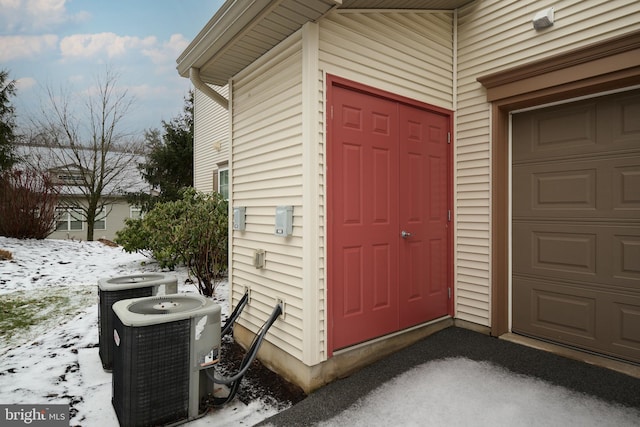 snow covered property entrance with central AC