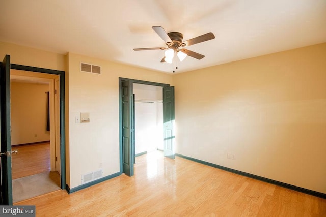 unfurnished bedroom with a closet, ceiling fan, and light wood-type flooring