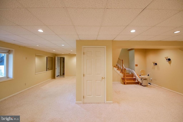 basement featuring a drop ceiling and carpet floors