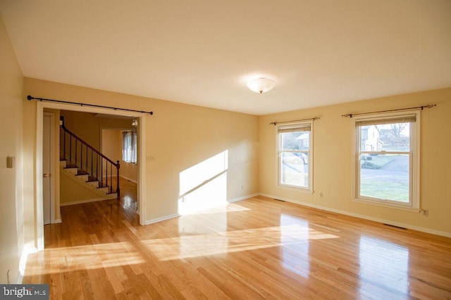 spare room featuring a barn door and light hardwood / wood-style floors