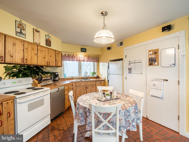 kitchen featuring sink, pendant lighting, fridge, stainless steel dishwasher, and electric stove