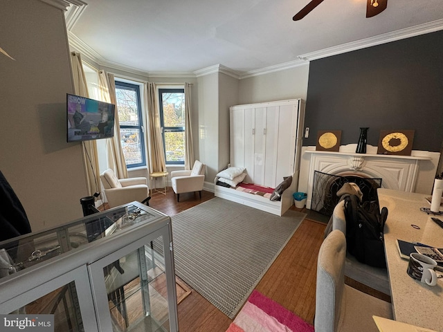 sitting room featuring crown molding, dark wood-type flooring, and ceiling fan