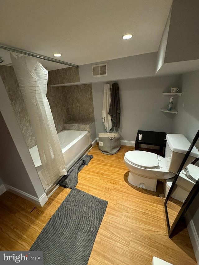 bathroom featuring hardwood / wood-style flooring, toilet, and independent shower and bath