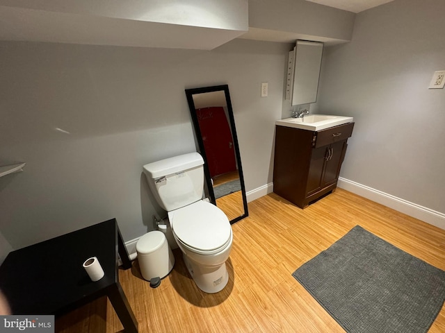 bathroom featuring wood-type flooring, vanity, and toilet