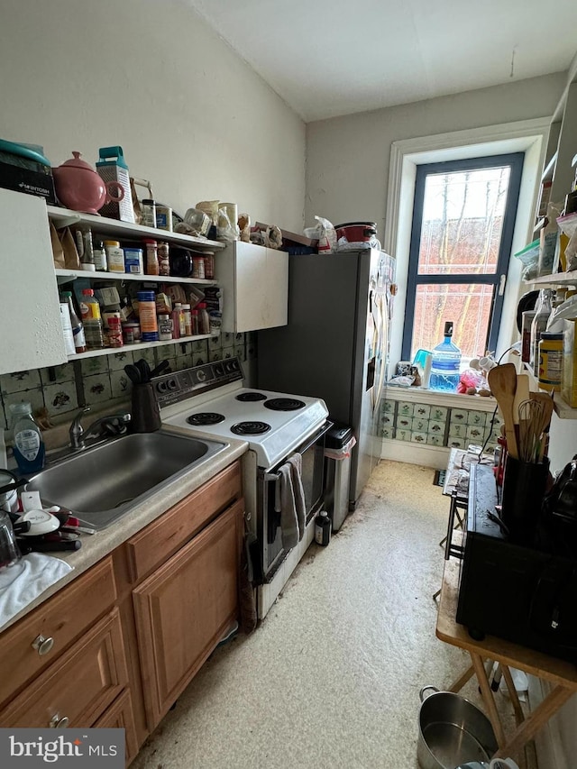 kitchen featuring stainless steel fridge with ice dispenser, sink, and white range with electric cooktop