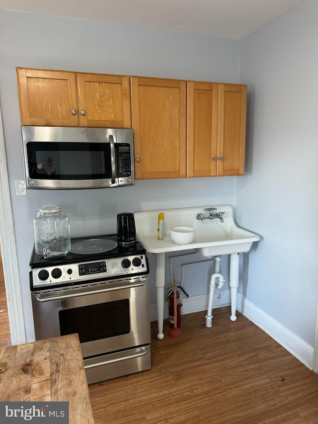 kitchen featuring dark hardwood / wood-style flooring and stainless steel appliances