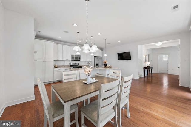 dining area with visible vents, baseboards, light wood-style flooring, recessed lighting, and a notable chandelier