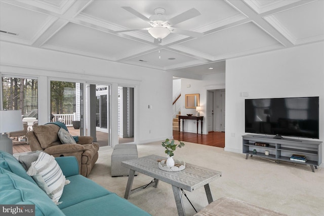 carpeted living room featuring baseboards, coffered ceiling, beam ceiling, ceiling fan, and stairs