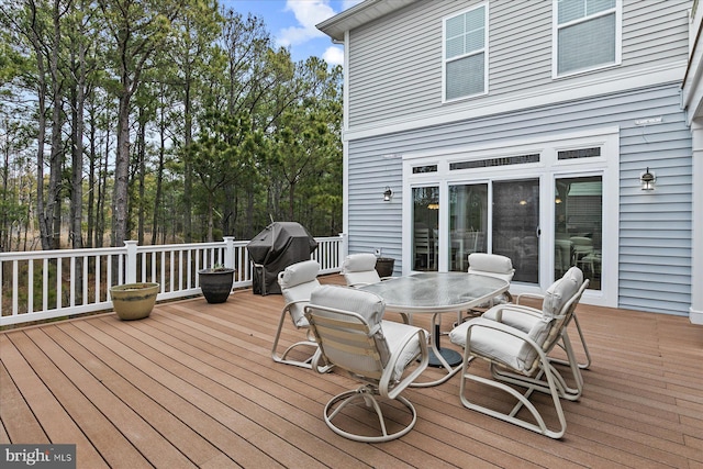 wooden deck featuring outdoor dining space and area for grilling