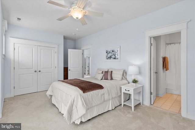 bedroom with visible vents, ceiling fan, light carpet, ensuite bathroom, and a closet