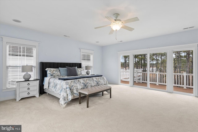 bedroom featuring visible vents, light colored carpet, a ceiling fan, and access to outside