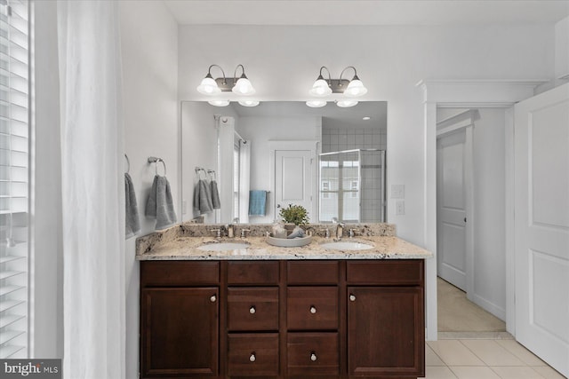 bathroom with a sink, a stall shower, double vanity, and tile patterned flooring