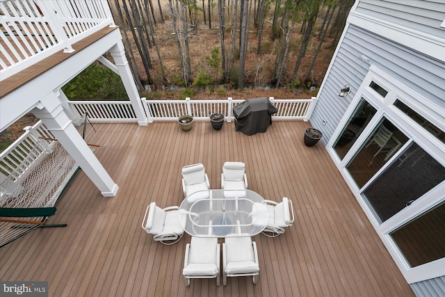 deck with outdoor dining space and grilling area