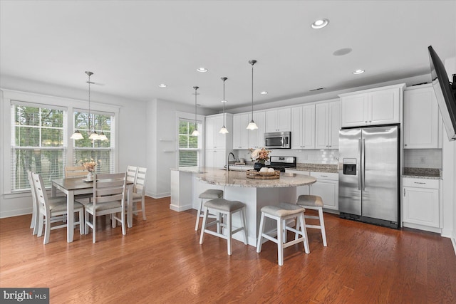 kitchen with stainless steel appliances, dark wood-type flooring, backsplash, and white cabinets