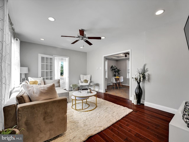 living room with dark wood-type flooring and ceiling fan