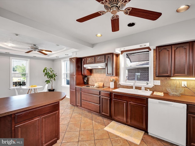 kitchen with tasteful backsplash, sink, white dishwasher, a tray ceiling, and black electric cooktop