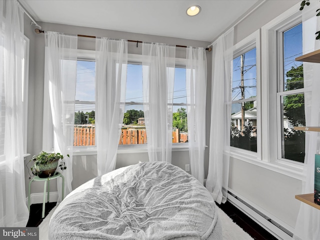 bedroom featuring baseboard heating and multiple windows