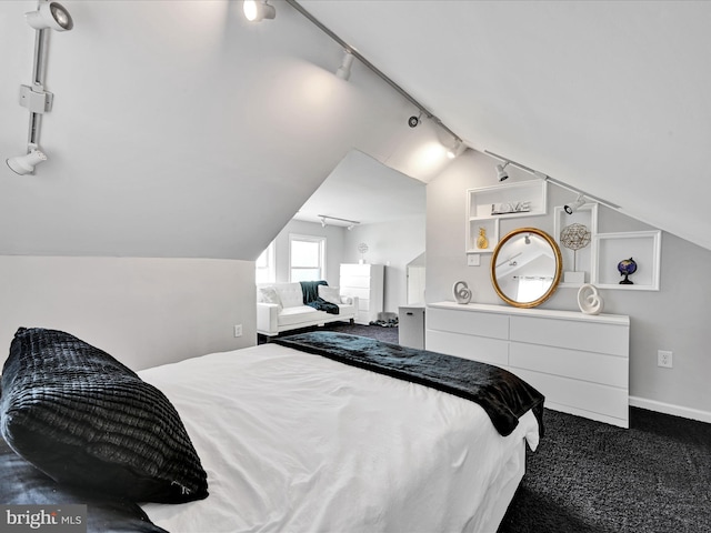 bedroom with vaulted ceiling, rail lighting, and carpet floors