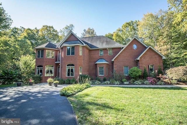 view of front of house with driveway, a front lawn, and brick siding