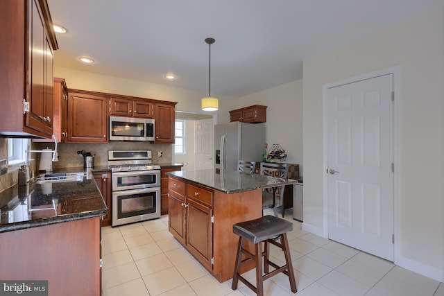 kitchen with stainless steel appliances, dark stone counters, light tile patterned flooring, and backsplash