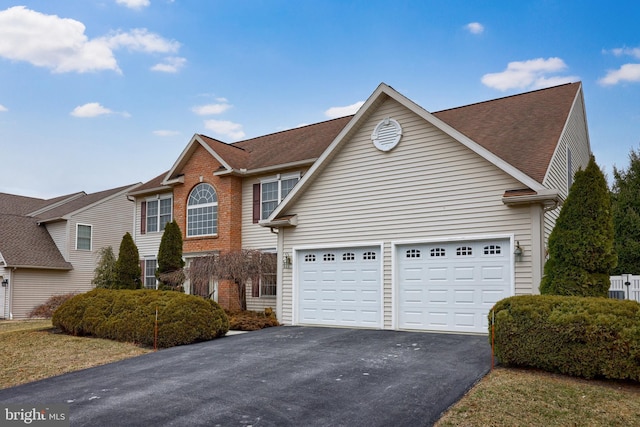 traditional-style house featuring aphalt driveway and brick siding