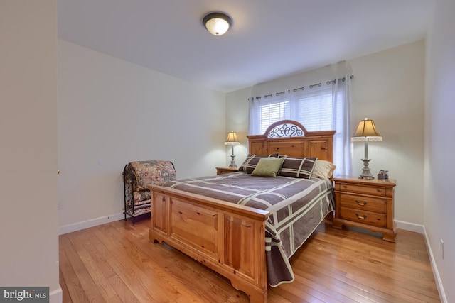 bedroom with light wood-style flooring and baseboards