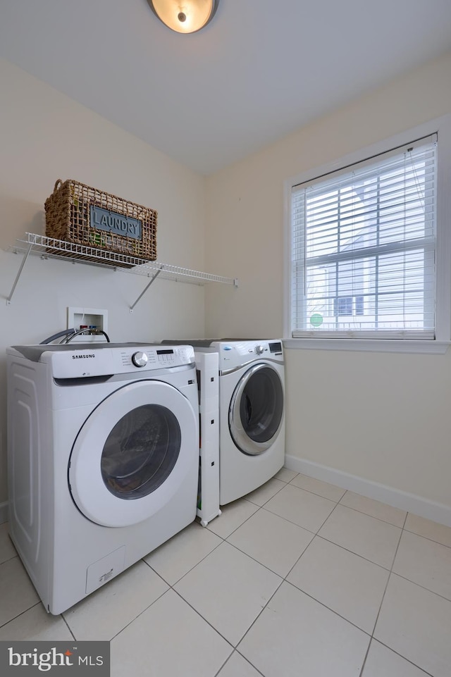 laundry area featuring light tile patterned floors, laundry area, baseboards, and washer and dryer