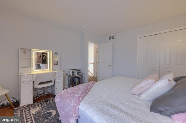 bedroom featuring dark wood-style floors, a closet, and visible vents