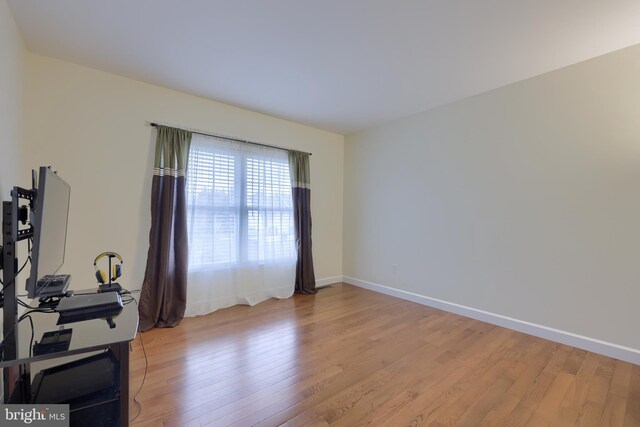 office area featuring light wood-type flooring and baseboards