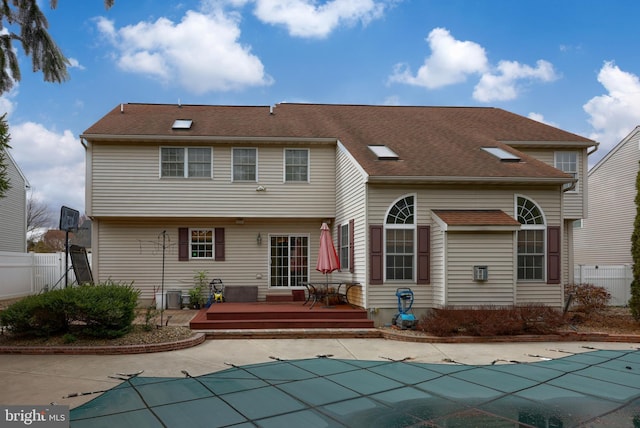 back of house with a patio area, a covered pool, fence, and a deck