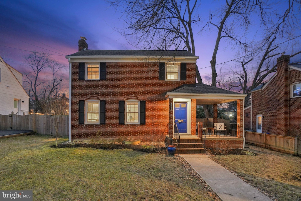 view of front facade with covered porch and a lawn