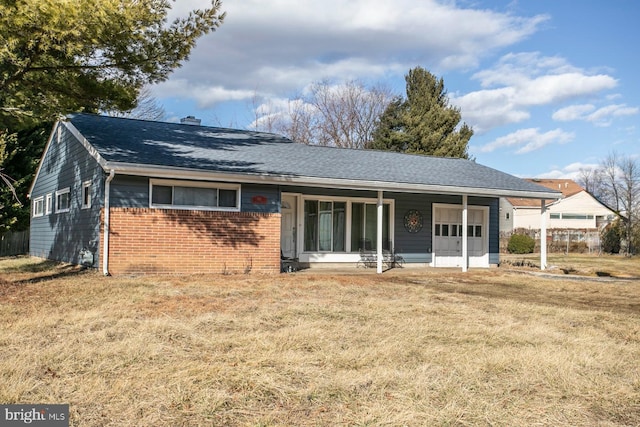 rear view of house with a porch and a lawn