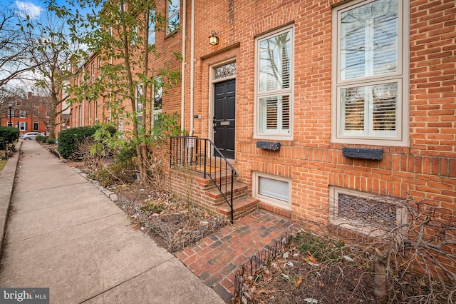 view of exterior entry with brick siding