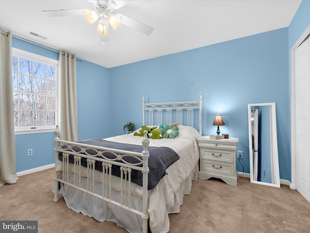 bedroom featuring baseboards, visible vents, a ceiling fan, and light colored carpet