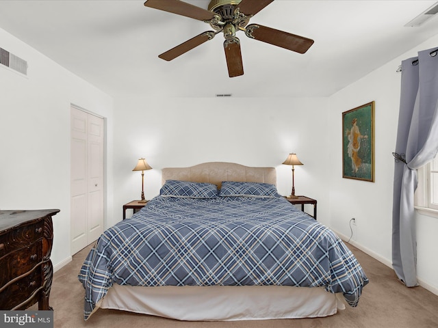 carpeted bedroom featuring a closet, visible vents, a ceiling fan, and baseboards