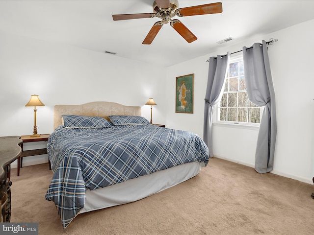 carpeted bedroom featuring visible vents, baseboards, and ceiling fan