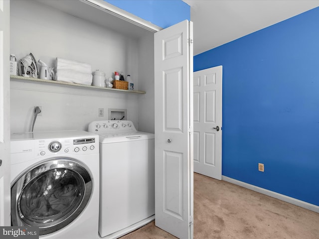 laundry room featuring washing machine and dryer, light carpet, laundry area, and baseboards
