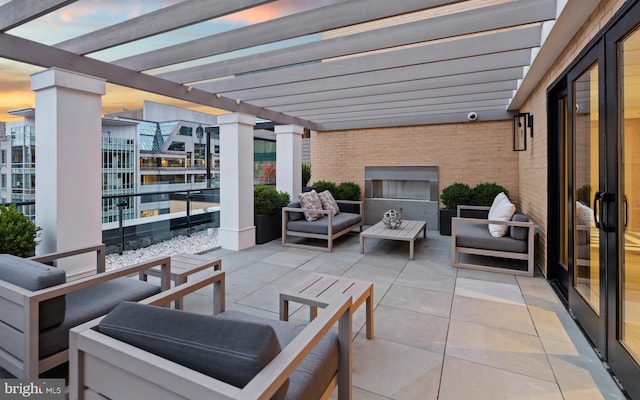 patio terrace at dusk with an outdoor hangout area and a pergola