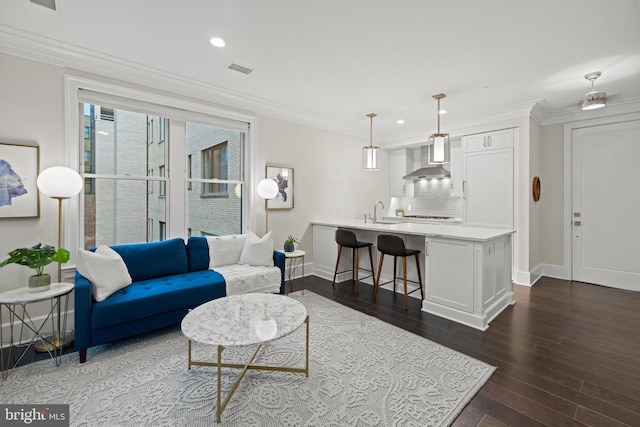 living area with recessed lighting, dark wood-style flooring, visible vents, baseboards, and ornamental molding