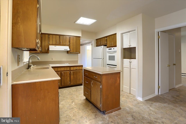 kitchen with white appliances, a center island, and sink